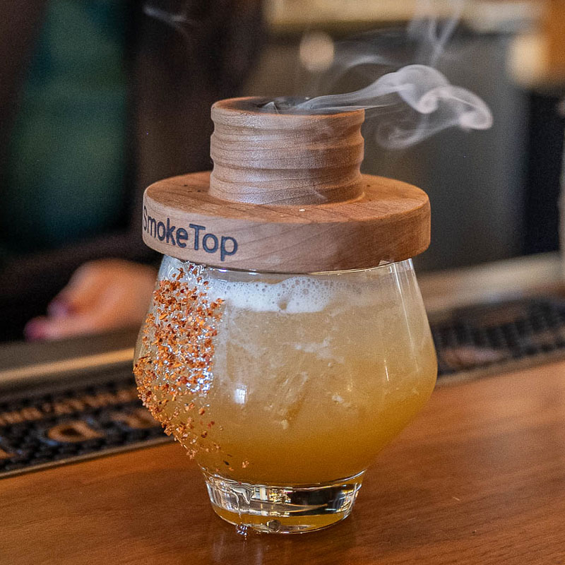 Cocktail made with a Smoke Top that is still smoking